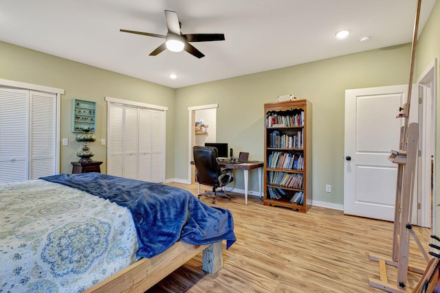 bedroom with ceiling fan, light wood-type flooring, and two closets