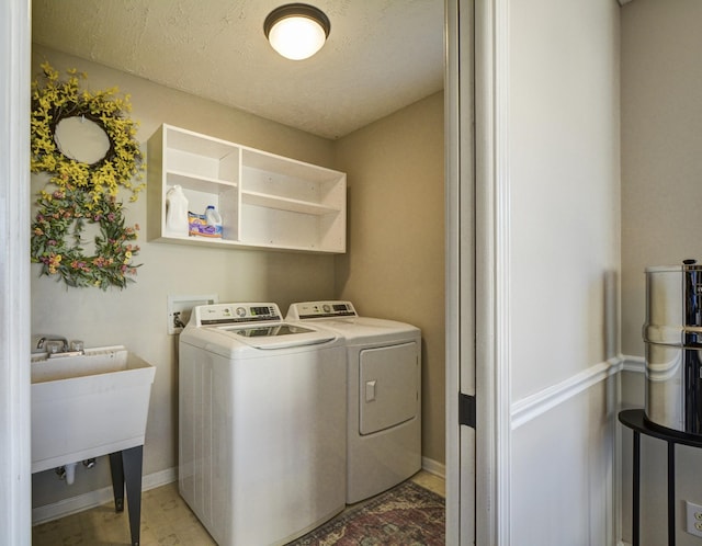 laundry area with separate washer and dryer, sink, and a textured ceiling