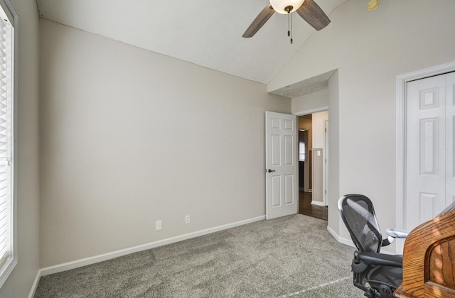 unfurnished office with ceiling fan, carpet flooring, and vaulted ceiling