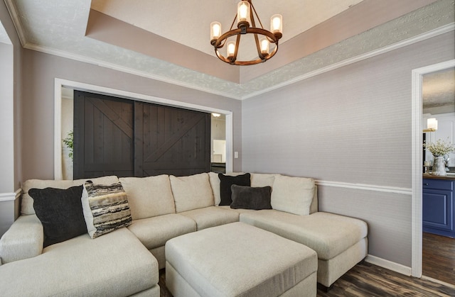 living room featuring a notable chandelier, crown molding, dark hardwood / wood-style floors, and a raised ceiling