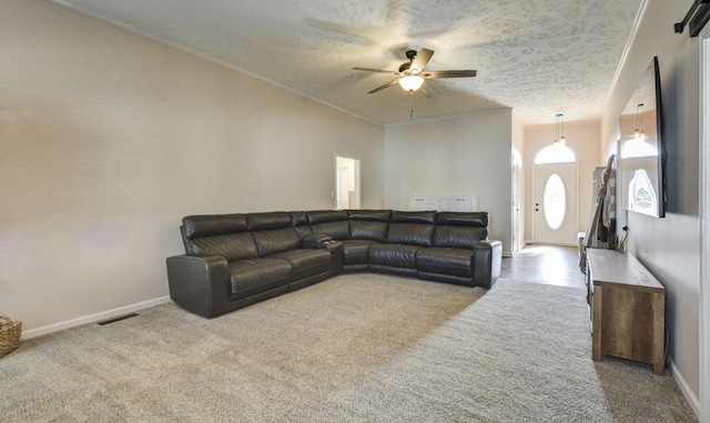 carpeted living room with a textured ceiling, ornamental molding, and ceiling fan