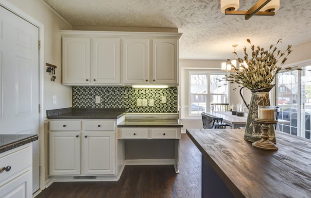 kitchen with a healthy amount of sunlight, dark wood-type flooring, and white cabinets