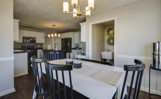 dining area featuring an inviting chandelier, dark hardwood / wood-style flooring, and a textured ceiling