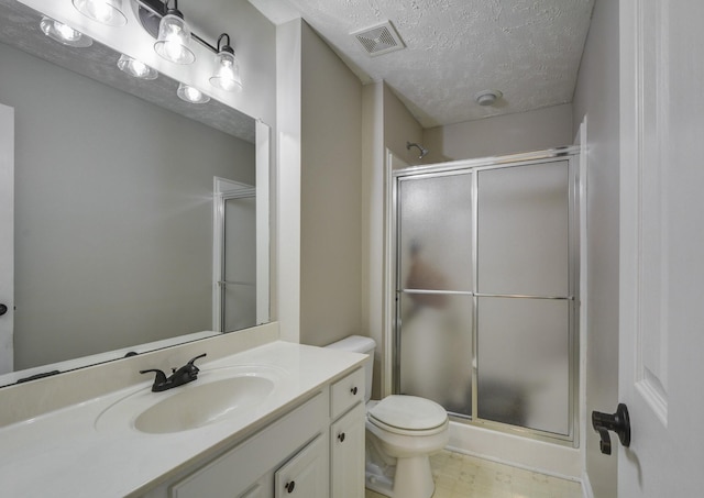 bathroom featuring walk in shower, vanity, toilet, and a textured ceiling