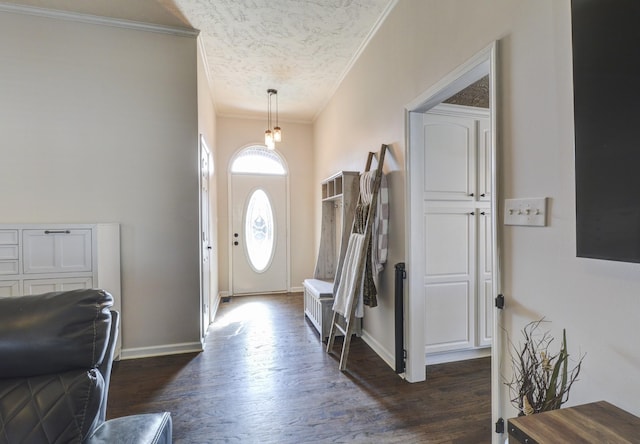 foyer entrance with ornamental molding, dark hardwood / wood-style floors, and a textured ceiling