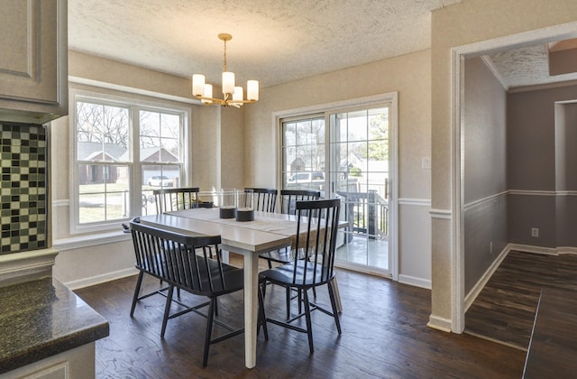 dining space featuring dark hardwood / wood-style floors, a chandelier, and a textured ceiling