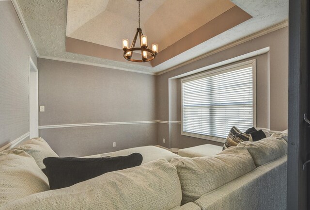 bedroom featuring an inviting chandelier, ornamental molding, and a raised ceiling