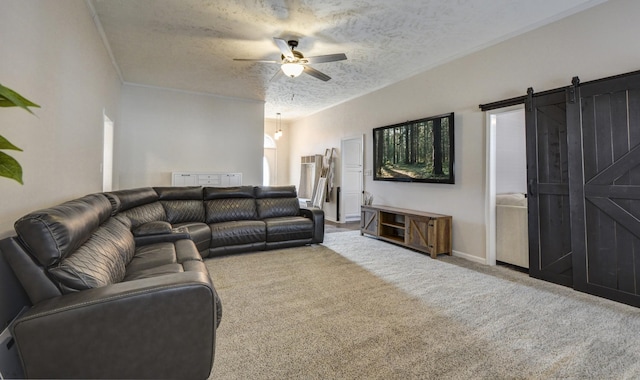 carpeted living room with ceiling fan, a barn door, and a textured ceiling