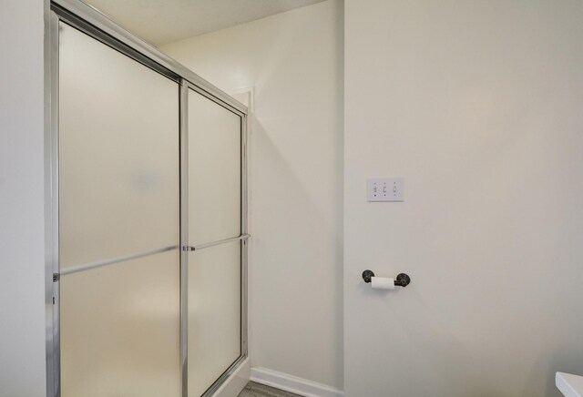 bathroom featuring a shower with shower door