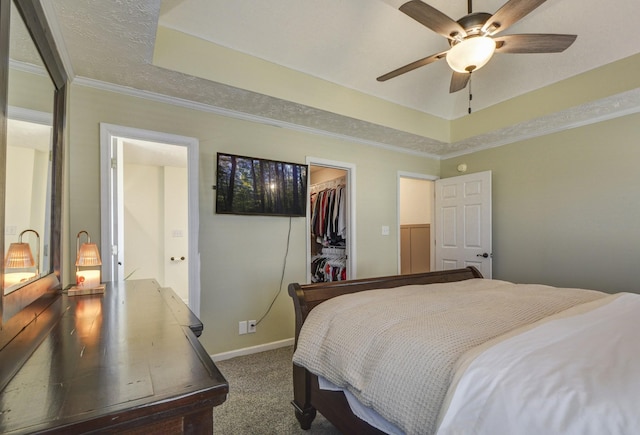 carpeted bedroom featuring ornamental molding, a tray ceiling, and a closet