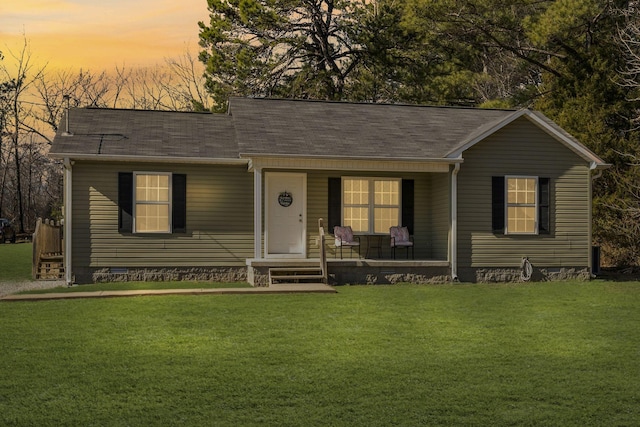 ranch-style home featuring a porch and a yard