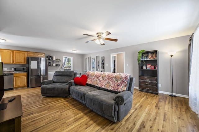 living room featuring ceiling fan and light wood-type flooring