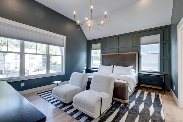 bedroom featuring an inviting chandelier, hardwood / wood-style floors, and high vaulted ceiling