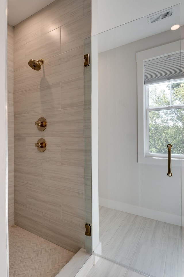 bathroom featuring a shower with door