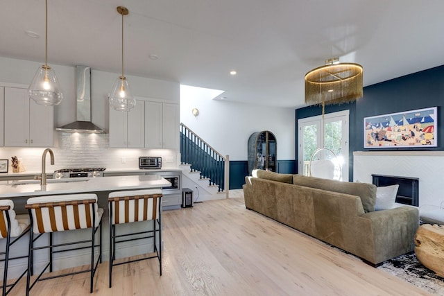 interior space featuring sink, light hardwood / wood-style flooring, and a tile fireplace