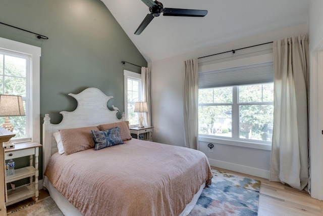 bedroom featuring vaulted ceiling, multiple windows, and light hardwood / wood-style flooring