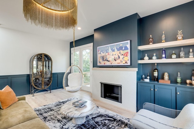 living room with built in shelves and hardwood / wood-style floors