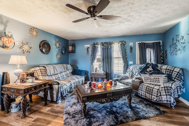 living room featuring ceiling fan, hardwood / wood-style floors, and a textured ceiling