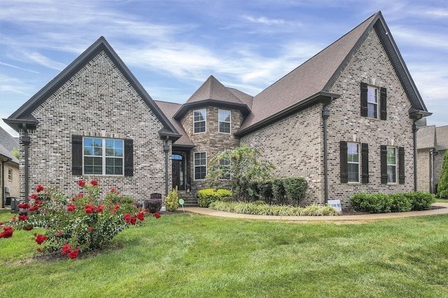 view of front of home with cooling unit and a front lawn