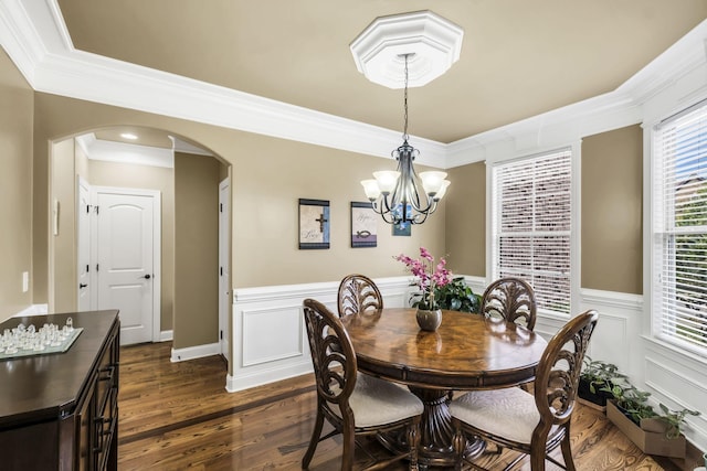 dining space with crown molding, dark hardwood / wood-style floors, and a notable chandelier