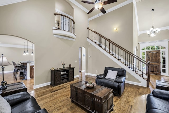 living room featuring hardwood / wood-style flooring, crown molding, and a high ceiling