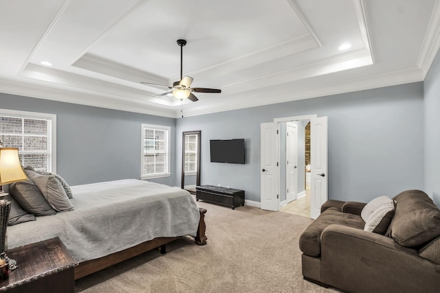 bedroom featuring ceiling fan, light colored carpet, ornamental molding, and a tray ceiling