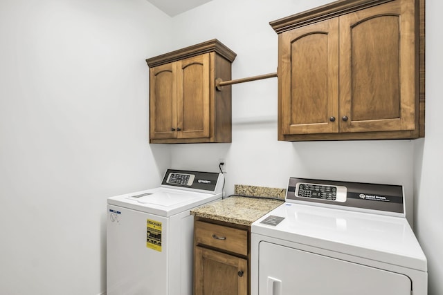 laundry area featuring cabinets and washer and clothes dryer