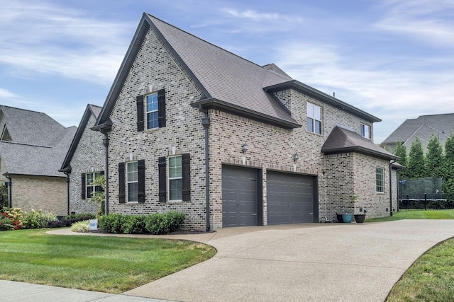 view of side of property with a garage and a lawn