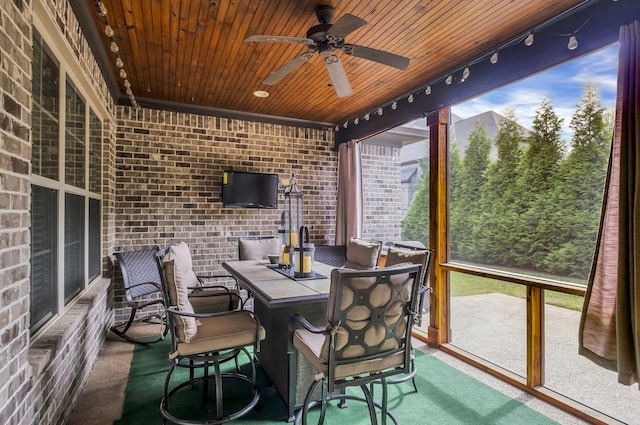 sunroom featuring wooden ceiling, rail lighting, and ceiling fan