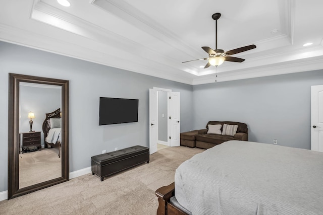 bedroom featuring crown molding, light carpet, ceiling fan, and a tray ceiling