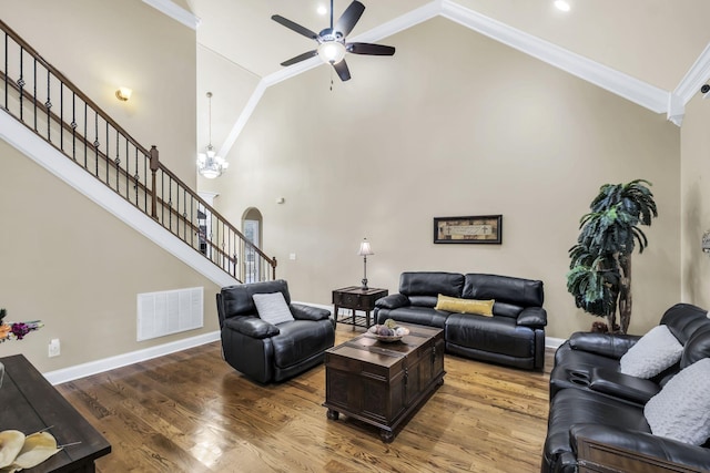 living room with hardwood / wood-style flooring, ceiling fan, ornamental molding, and high vaulted ceiling