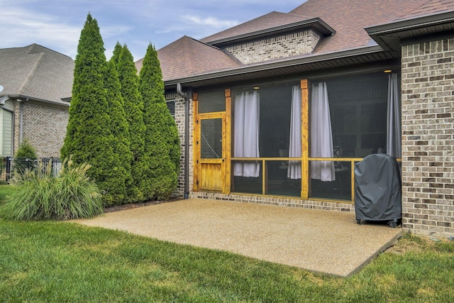 entrance to property featuring a yard and a patio