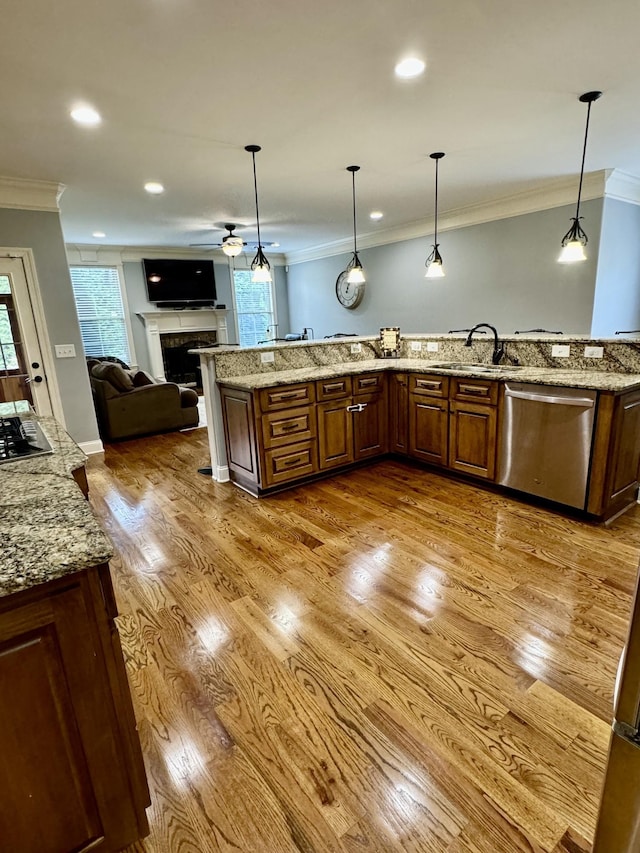 kitchen with stainless steel appliances, crown molding, hanging light fixtures, and sink