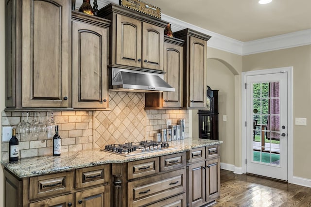 kitchen featuring extractor fan, dark hardwood / wood-style flooring, stainless steel gas cooktop, crown molding, and light stone countertops