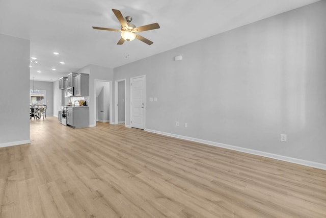 unfurnished living room featuring recessed lighting, baseboards, light wood finished floors, and ceiling fan