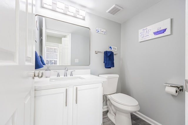 bathroom featuring vanity, wood-type flooring, and toilet