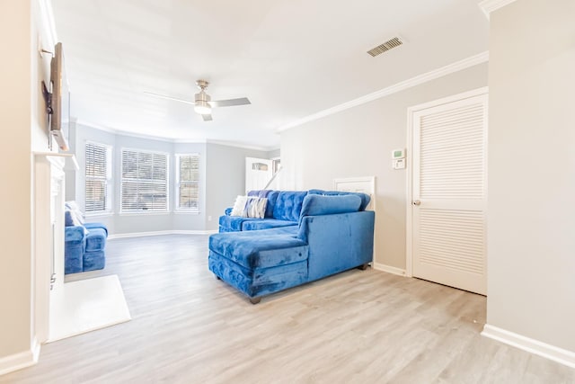 living room featuring ceiling fan, ornamental molding, and light hardwood / wood-style flooring