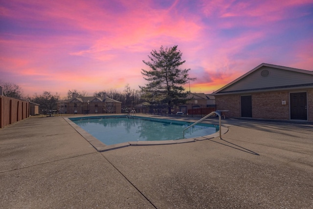 pool at dusk with a patio area