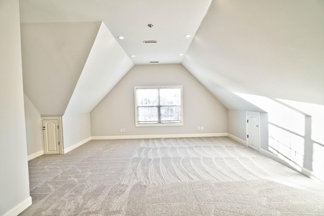 bonus room featuring vaulted ceiling and light carpet