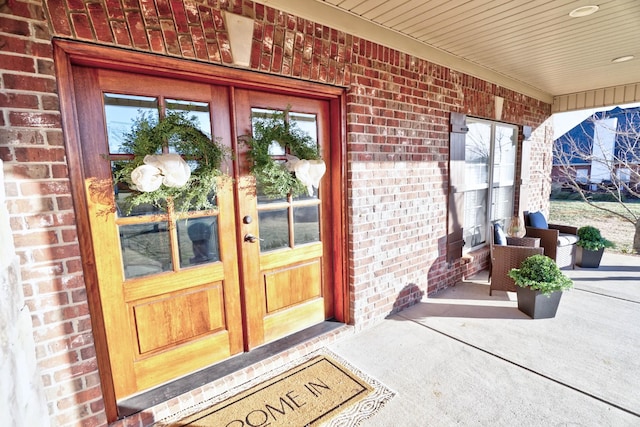 view of exterior entry with french doors and a porch