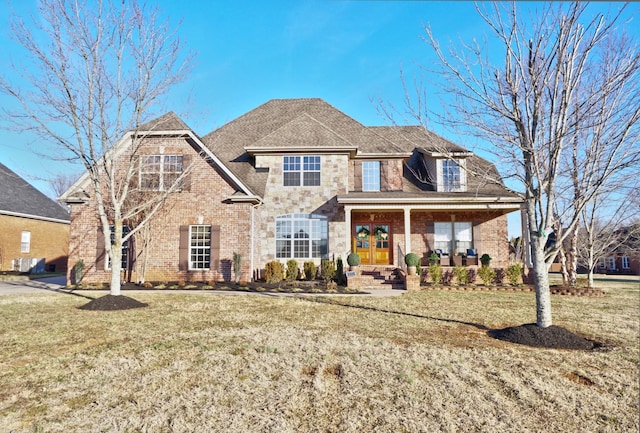 view of front of home featuring french doors, a porch, and a front lawn