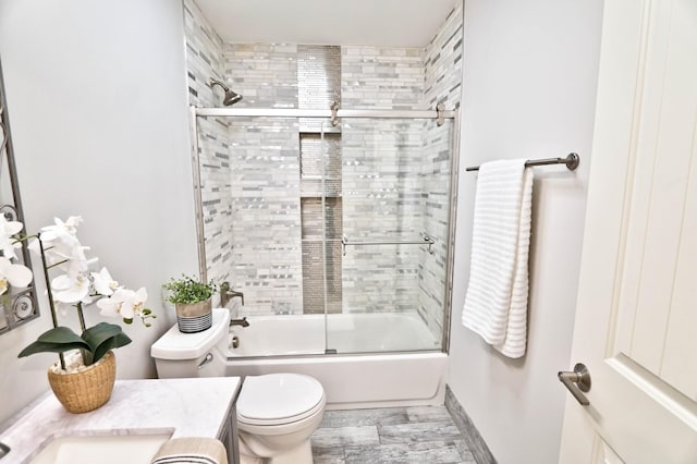 full bathroom featuring vanity, bath / shower combo with glass door, and toilet