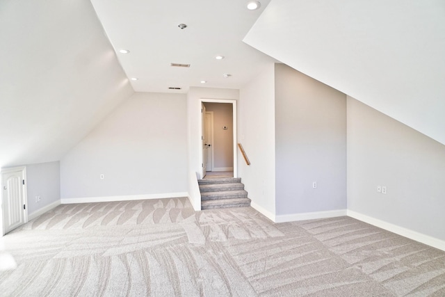 additional living space with vaulted ceiling and light carpet