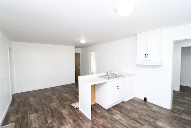 kitchen with dark hardwood / wood-style flooring, sink, kitchen peninsula, and white cabinets