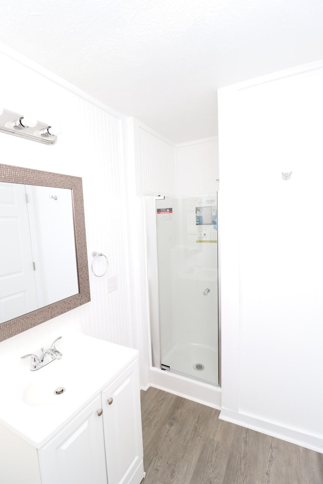 bathroom featuring hardwood / wood-style flooring, vanity, and a shower with shower door