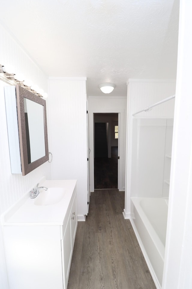 bathroom featuring vanity, hardwood / wood-style flooring, and  shower combination