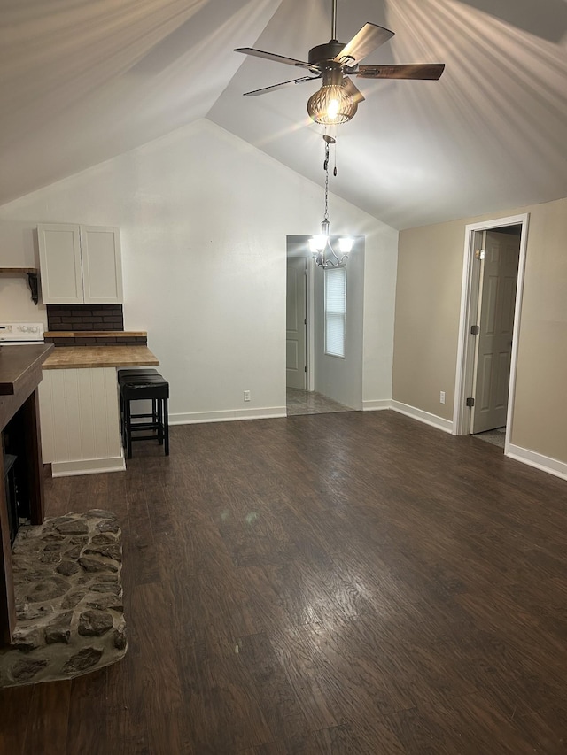 unfurnished living room featuring vaulted ceiling, dark wood-type flooring, and ceiling fan with notable chandelier