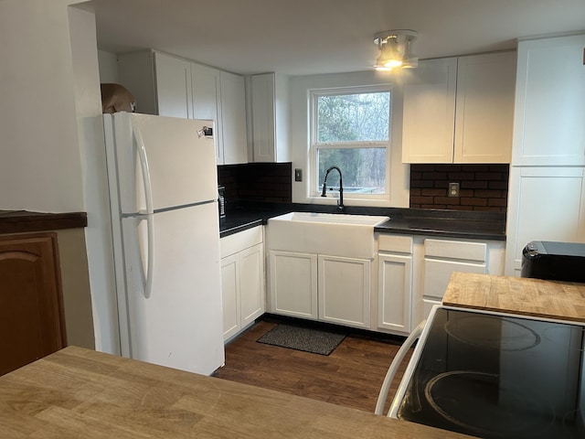 kitchen with white refrigerator, range with electric stovetop, sink, and white cabinets