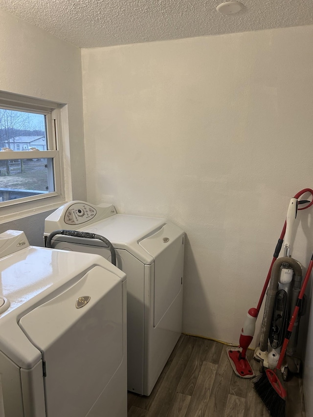 laundry area featuring separate washer and dryer, a textured ceiling, and dark hardwood / wood-style flooring