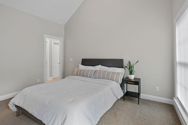 carpeted bedroom featuring lofted ceiling and multiple windows